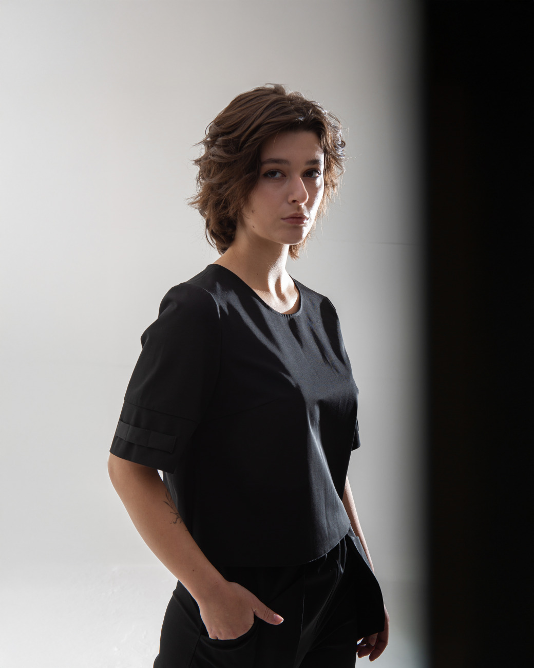 top t shirt with small openings for scissors and hair clips located on the sleeve, designed for women hairstylists